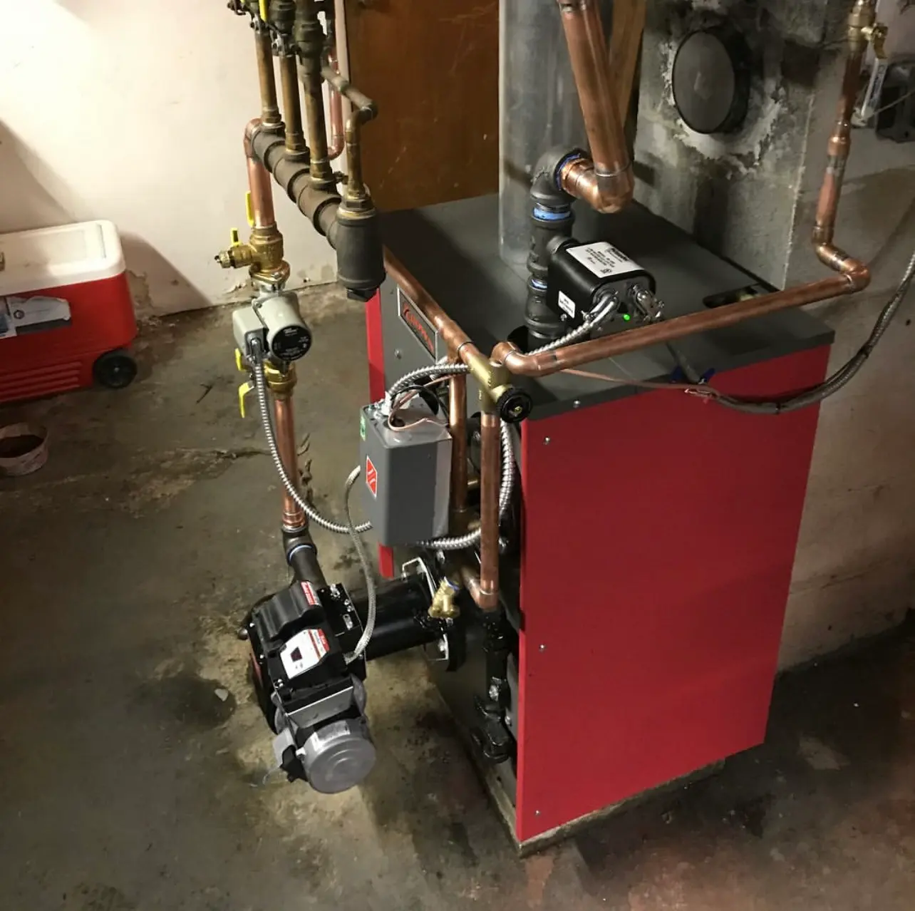 HVAC and plumbing Cold Spring NY, red boiler and copper piping in an older home's basement