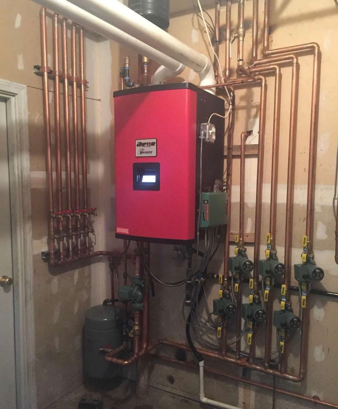HVAC and plumbing Beacon NY, wall-hung boiler with zone valves and a copper manifold in a basement